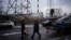 FILE - Utility workers walk next to a power plant after a missile attack in Kyiv, Ukraine, Jan. 26, 2023.