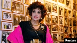 FILE - Italian film icon Gina Lollobrigida poses near a wall of celebrity photos in her villa in southern Rome December 7, 2006.