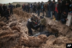 People bury loved ones — victims of Monday's earthquake — in Adiyaman, Turkey, Feb. 10, 2023.