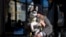 Madeleine Russell, buries her face into the fur of her 4-month-old husky, Stevie Nicks, to stay warm while waiting for a friend outside a coffee shop in Providence, RI, Feb. 3, 2023. 