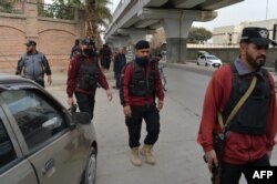 Policemen patrol along a street in Peshawar, Feb. 1, 2023, days after a mosque suicide blast inside a police headquarters.