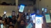 Migrants hold up their phones showing the CBPOne app at a shelter Jan 22, 2023, in Tijuana, Mexico. 