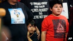 FILE - Family of those killed by a gunman at Robb Elementary School in Uvalde, Texas, stand with state Sen. Roland Gutierrez during a news conference at the Texas Capitol in Austin, Jan. 24, 2023. Gutierrez says he is filing legislation in the wake of Texas' rising gun violence.