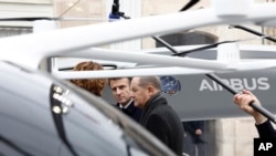 French President Emmanuel Macron, center, and German Chancellor Olaf Scholz, right, take a reporter's question as they attend the presentation of Franco-German industrial projects, at the Elysee Palace in Paris, Jan. 22, 2023.