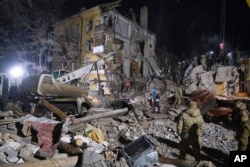 Petugas darurat membersihkan puing-puing setelah roket Rusia menghantam sebuah gedung apartemen di Kramatorsk, Ukraina, 2 Februari 2023. Sedikitnya 3 orang tewas dan 21 luka-luka dalam serangan itu. (Foto: AP/Yevgen Honcharenko)