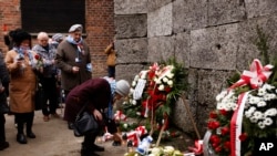 ဂျူးလူမျိုးတွေအစုလိုက်အပြုံလိုက် သတ်ဖြတ်ခံရတဲ့ Auschwitz အကျဉ်းထောင်ရှေ့မှာ သေဆုံးသူတွေကို အမှတ်တရလာရောက်ဂါရဝပြုကြစဉ်။ (ဇန်နဝါရီ ၂၇၊ ၂၀၂၃) 