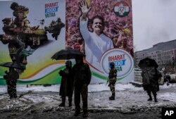 Indian soldiers and policemen stand guard at an opposition public rally as it snows in Srinagar, Indian controlled Kashmir, Monday, Jan. 30, 2023.