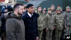 British Prime Minister Rishi Sunak and Ukrainian President Volodymyr Zelenskyy meet Ukrainian troops being trained to command Challenger 2 tanks at a military facility in Lulworth, Dorset, England, Feb. 8, 2023.