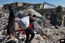 Warga mencari korban di antara puing-puing bangunan yang runtuh tempat bayi perempuan yang baru lahir ditemukan di Kota Jinderis, Aleppo, Suriah, Selasa, 7 Februari 2023. (Foto: AP)