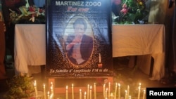 Candles are kept in front of Cameroon journalist Martinez Zogo's photo as fellow journalists pay their last respect to him after he was found dead after abduction, in Yaounde, Cameroon, Jan. 23, 2023. 