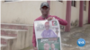 Ayomide Benjamin Feyijimi shows his manifesto while speaking to constituents on during his campaign for House of Assembly