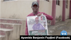 Ayomide Benjamin Feyijimi shows his manifesto while speaking to constituents on during his campaign for House of Assembly