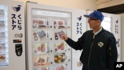 Konomu Kubo, a spokesperson for Kyodo Senpaku Co. explains how whale meat is being sold from a vending machine at the firm's store, Jan. 26, 2023, in Yokohama, Japan. 