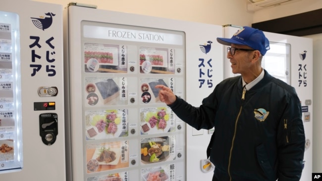 Konomu Kubo, a spokesperson for Kyodo Senpaku Co. explains how whale meat is being sold from a vending machine at the firm's store, Jan. 26, 2023, in Yokohama, Japan.