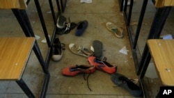 FILE - Sepatu siswa Sekolah Menengah Ilmu Pemerintahan yang diculik terlihat di dalam ruang kelas mereka di Kankara, Nigeria, Rabu, 16 Desember 2020. Pemberontak dari kelompok ekstremis Boko Haram mengaku bertanggung jawab. (AP/Minggu Alamba, Files)