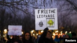 People hold signs referencing Leopard tanks being sent to Ukraine, at a demonstration in Berlin, Germany, Jan. 20, 2023.