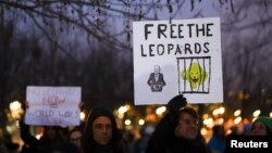 People hold signs referencing Leopard tanks being sent to Ukraine, at a demonstration in Berlin, Germany, Jan. 20, 2023.