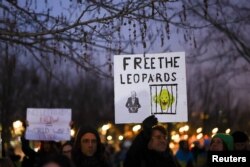 FILE - People hold signs referencing Leopard tanks being sent to Ukraine, at a demonstration in Berlin, Germany, Jan. 20, 2023.