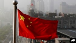 Bendera nasional China berkibar di gedung perkantoran di Shanghai, China, sebagai ilustrasi. Seorang utusan terkemuka China akan memulai lawatan ke Ukraina, Rusia dan negara-negara Eropa lainnya pada Senin (15/5). (Foto: AP)