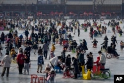 FILE - Visitors enjoy skating on the crowded frozen Houhai Lake in Beijing, China, Jan. 30, 2023. But, do not skate on thin ice! (AP Photo/Andy Wong)
