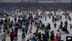 Warga tampak memadati area berseluncur di Danau Houhai yang membeku di Beijing, China, pada 30 Januari 2023. (Foto: AP/Andy Wong)