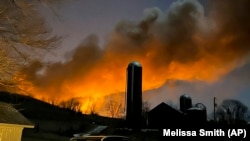 En esta foto proporcionada por Melissa Smith, se ve un tren en llamas desde su granja en East Palestine, Ohio, el 3 de febrero de 2023.