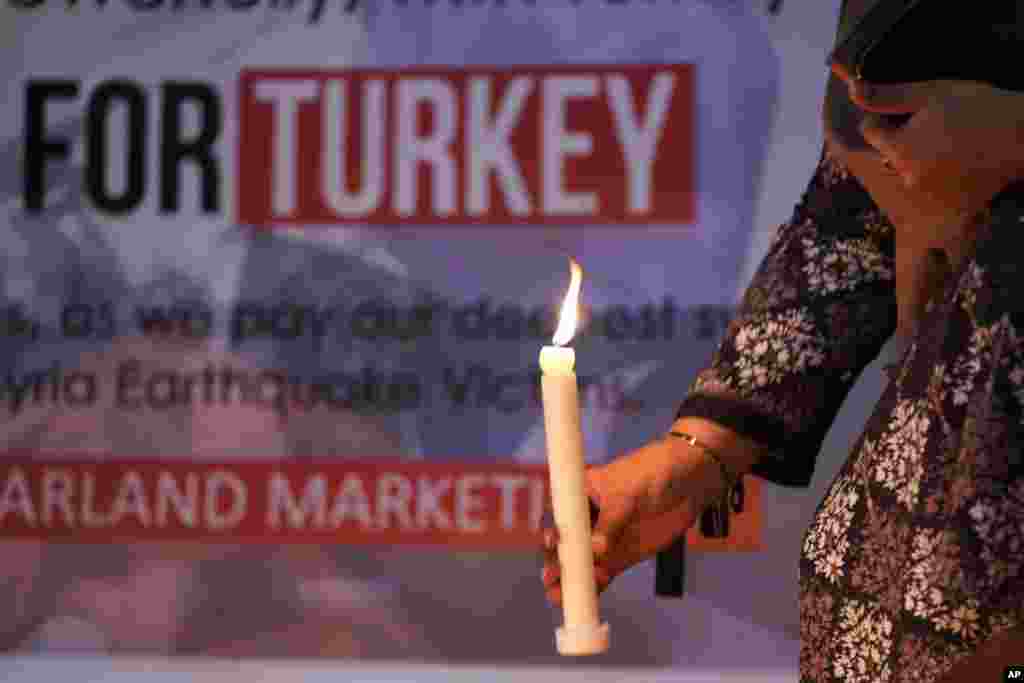 A woman holds a candle during a candlelight vigil for the victims of earthquake in Syria and Turkey, in Islamabad, Pakistan, Feb. 6, 2023. 