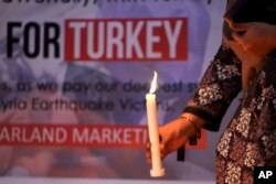 巴基斯坦一名女子在伊斯兰堡手持蜡烛悼念土耳其和叙利亚地震死难者。（2023年2月6日）