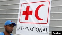资料照：一名委内瑞拉工作人员走过贴有国际红十字会和红新月会标识的人道救援物资卡车。（2019年4月16日）