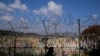 FILE - A visitor walks near the wire fences decorated with ribbons with messages wishing for the reunification of the two Koreas at the Imjingak Pavilion in Paju, South Korea, Oct. 28, 2022. 