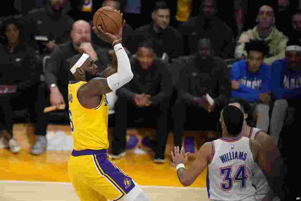 Los Angeles Lakers forward LeBron James, left, scores to pass Kareem Abdul-Jabbar to become the NBA&#39;s all-time leading scorer as Oklahoma City Thunder guard Josh Giddey,&nbsp;right, and forward Kenrich Williams defend&nbsp; during the second half of an NBA basketball game, Feb. 7, 2023, in Los Angeles.