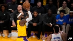 LeBron James, kiri, menjadi pencetak gol terbanyak sepanjang masa NBA sebagai guard Oklahoma City Thunder Josh Giddey, selama paruh kedua pertandingan bola basket NBA, 7 Februari 2023, di Los Angeles. (Foto: AP)