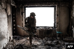 Seorang tentara Ukraina dari Layanan Penjaga Perbatasan tampak siaga di sebuah gedung yang rusak di kota Bakhmut, Ukraina, 9 Februari 2023.