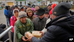 Warga Ukraina antre menunggu roti gratis dari relawan di kota Bakhmut, lokasi pertempuran terberat melawan pasukan Rusia di wilayah Donetsk, Ukraina (foto: dok). 