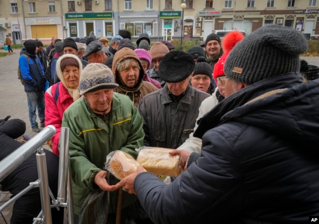 Local residents stand in line waiting for free bread from volunteers in Bakhmut, the site of the heaviest battle against the Russian troops in the Donetsk region, Ukraine, Friday, Oct. 28, 2022. (AP Photo/Efrem Lukatsky, File)