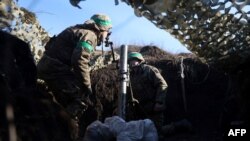 A Ukrainian serviceman gets ready to fire with a mortar from a position near Bakhmut, in Ukraine's Donetsk region, Jan. 27, 2023. There were conflicting claims Sunday over who controls the nearby village of Blahodatne.