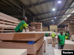 FILE - Workers check the quality of plywood made in Gabon's Special Economic Zone in Nkok, Gabon, Oct. 12, 2021.