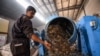 A worker dumps plastic out of a mixer before it is recycled into tiles at the startup known as TileGreen, based near Egypt's capital, on Dec. 8, 2022.