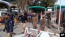 Tentara dan polisi membuka jalan bagi ambulans yang sedangn menuju lokasi ledakan bom di Peshawar, Pakistan, Senin, 30 Januari 2023. (Foto: AP)