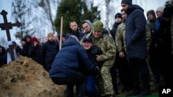 Anja Korostenska pada na koljena pred grobom svog verenika, Oleksija Zavadskog, ukrajinskog vojnika koji je poginuo u borbi 15. januara u Bahmutu, tokom njegove sahrane u Buči, Ukrajina, 19. januara 2023.