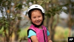 Rylae-Ann Poulin smiles as she learns to ride a horse in Bangkok, Thailand, Saturday, Jan. 14, 2023. (AP Photo/Sakchai Lalit)