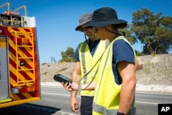 Petugas Pemadam Kebakaran dan Layanan Darurat melakukan pencarian kapsul radioaktif yang diyakini jatuh dari truk yang sedang diangkut di jalur barang di pinggiran Perth, Australia, Sabtu, 28 Januari 2023. (Departemen Pemadam Kebakaran dan Layanan Darurat via AP)