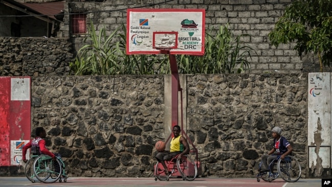 FILE - Paul Mitemberezi, a market vendor who has been disabled since he was 3 because of polio, plays basketball at the North Kivu Paralympic League, in Goma, democratic Republic of Congo, Jan. 17, 2023.