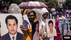 FILE - People holding photos of their near and dear ones — who are alleged victims of enforced disappearance — silently demonstrating in Dhaka, Bangladesh, Aug. 30, 2022. (Abdur Rajjak/VOA)