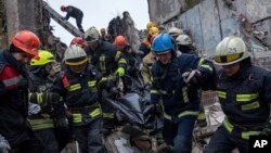 Rescue workers carry the body of a man who was killed in a Russian missile strike on an apartment building in the southeastern city of Dnipro, Ukraine, Jan. 16, 2023.