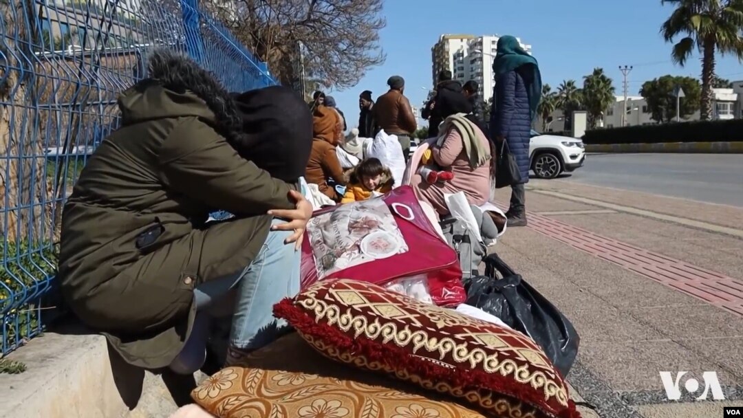 خێزانێکی سوریای لە پاش بوومەرزەکەی تورکیا لەسەر شەقامێکی مێرسین