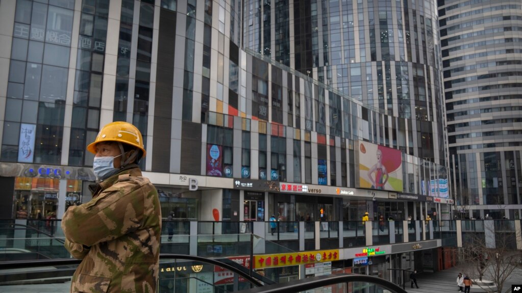 一名身穿工装的工人乘坐电梯到达北京一个空荡荡的商贸区。（2023年1月11日）(photo:VOA)