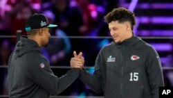 El mariscal de campo de los Philadelphia Eagles, Jalen Hurts, a la izquierda, y el mariscal de campo de los Kansas City Chiefs, Patrick Mahomes, se dan la mano durante la noche inaugural del Super Bowl 57 de la NFL, el lunes 6 de febrero de 2023, en Phoenix.