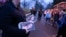 An attendant holds programs as fans enter Graceland for a memorial service for Lisa Marie Presley, Jan. 22, 2023, in Memphis, Tenn. 