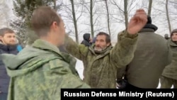 A still image from video released on Feb. 4, 2023 by Russia's Defense Ministry shows who it said are Russian servicemen released in the latest exchange of prisoners of war at an unknown location during the Russia-Ukraine conflict.